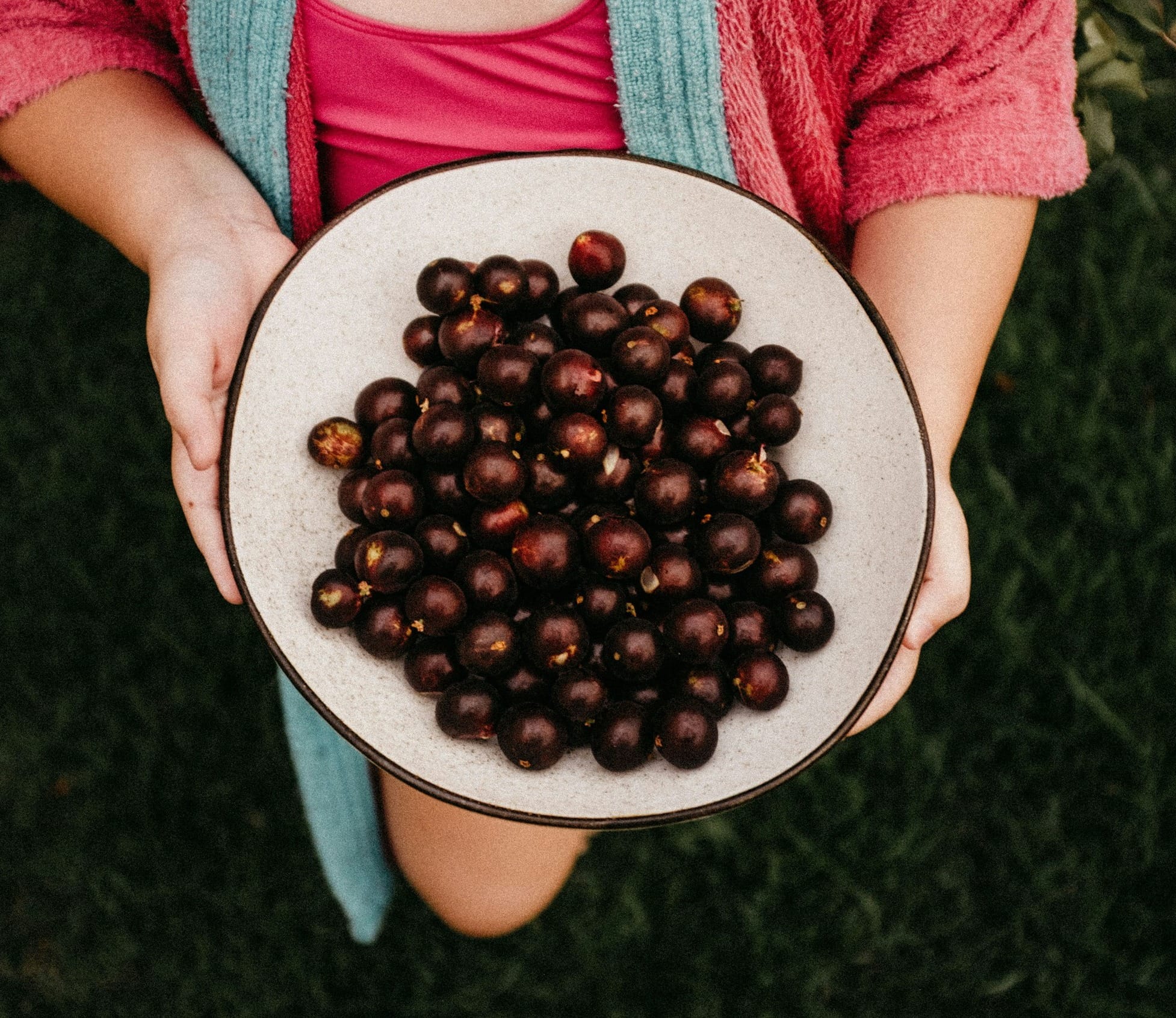 a girl holding a plate of chestnuts in her hands